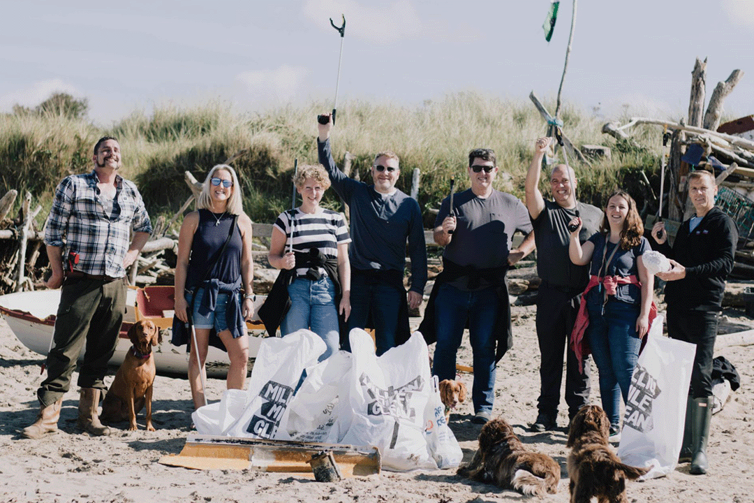 An image of a group of people cleaning up litter from a beach for Surfers Against Sewage.