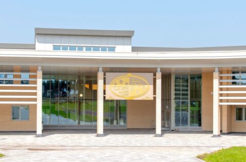 A modern, single-story building with large glass windows and a flat roof.
