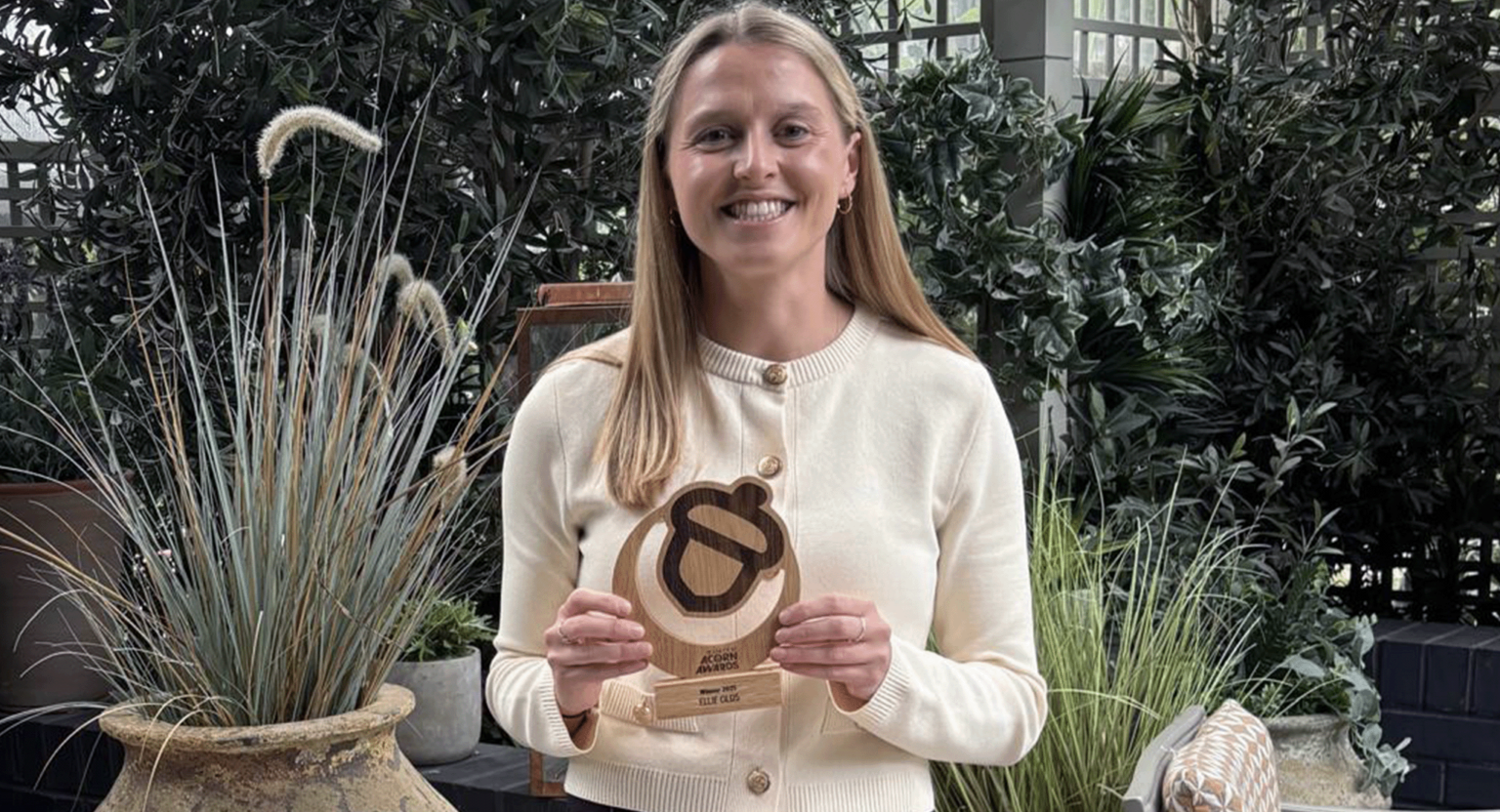 Ellie Olds. Holroyd Howe's nutritionist holding a 30 under 30 acorn award