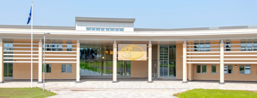 A modern, single-story building with large glass windows and a flat roof.