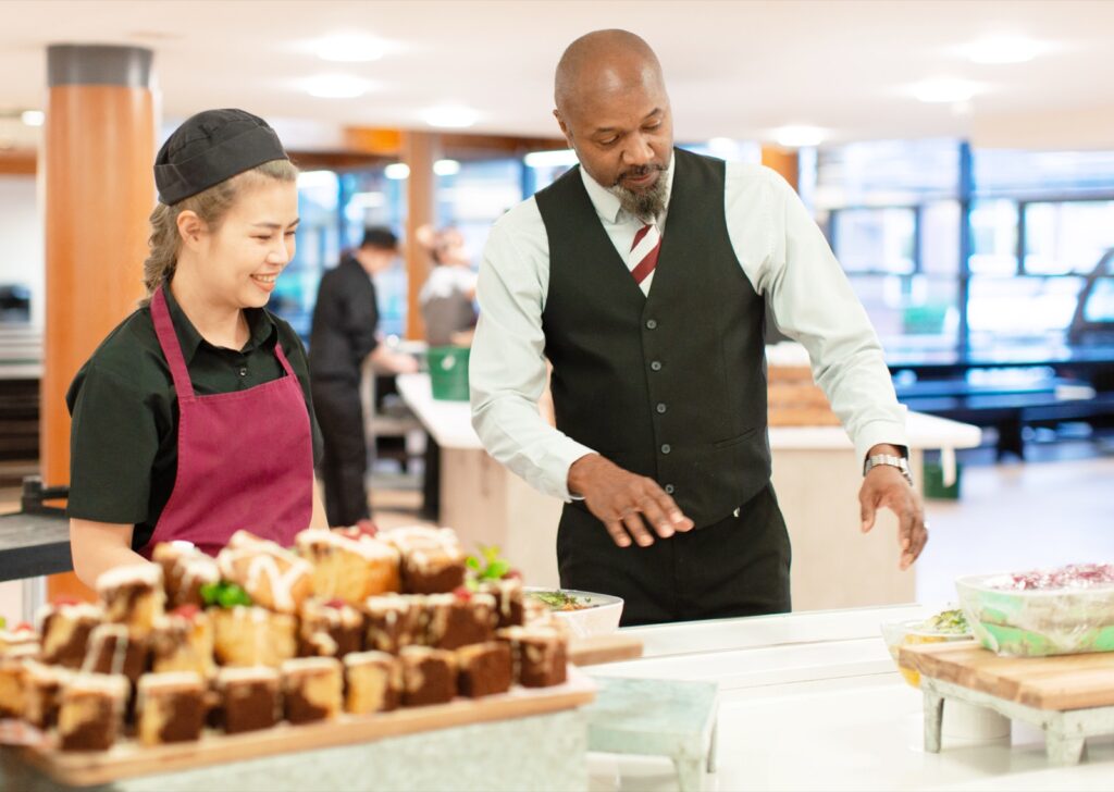 Home 36 Holroyd Howe team serving homemade bakes at a school dining counter